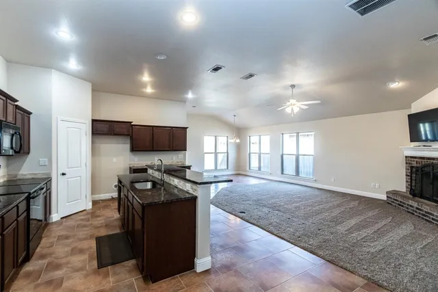 a kitchen with sink stove and refrigerator