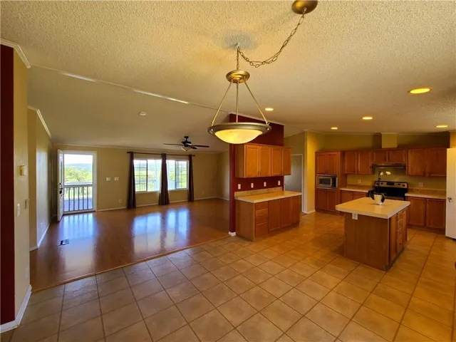 a view of a living room and kitchen with granite countertop lots of stainless steel appliances