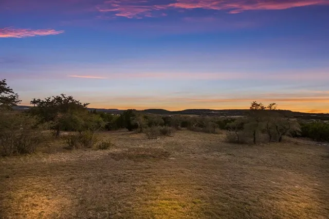 a view of mountain with sunset in background