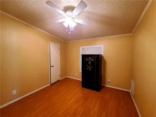 en empty room with a ceiling fan and wooden floor