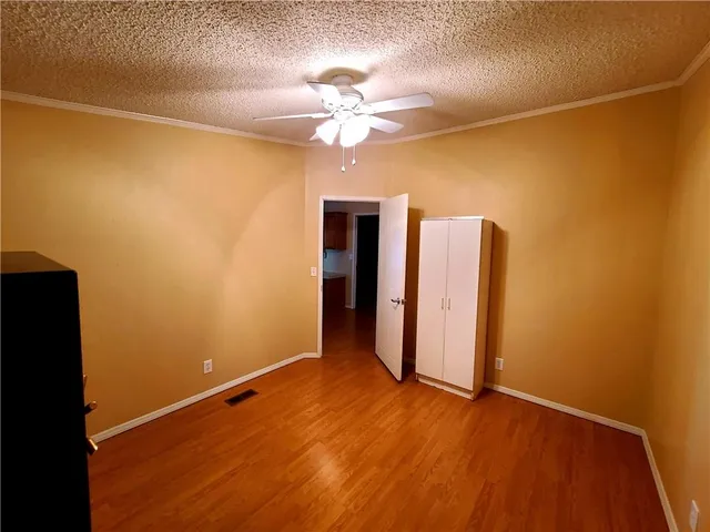 a view of a room with a ceiling fan and wooden floor