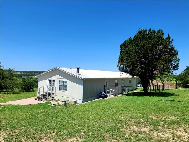 a front view of a house with a yard and green space