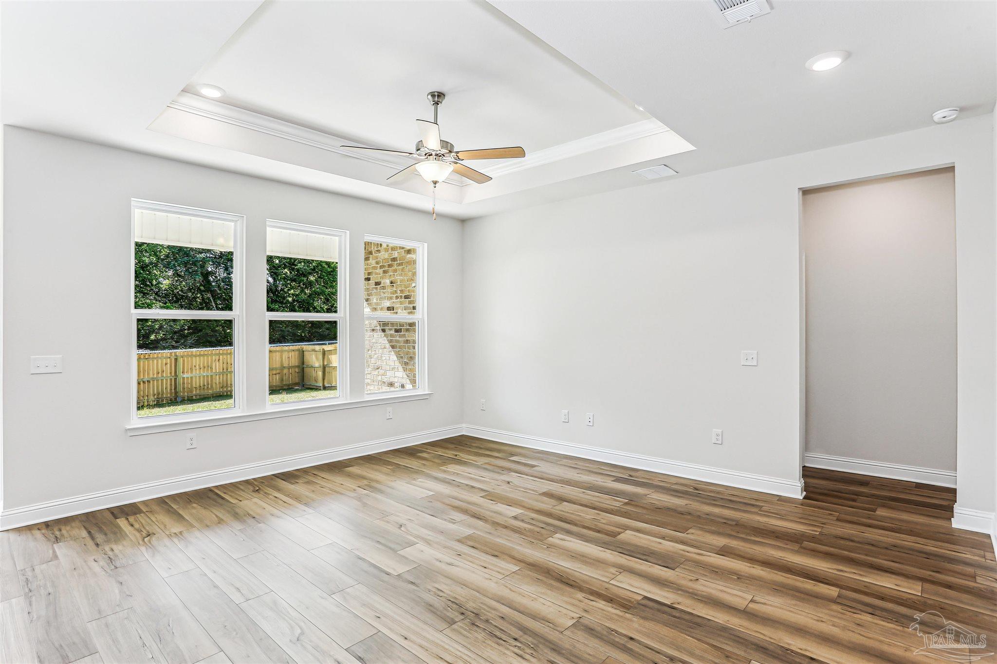 1644 Slate Drive Cantonment, FL 32533 - Photo 4 of 28 an empty room with wooden floor and windows