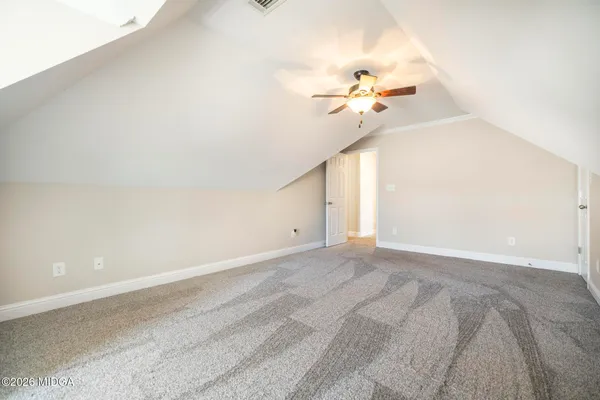 an empty room with a window and a ceiling fan