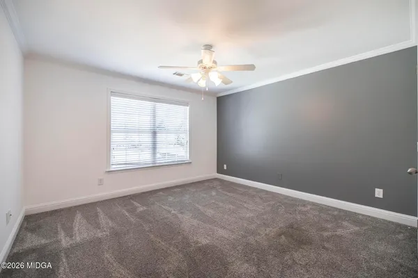 an empty room with windows and fan