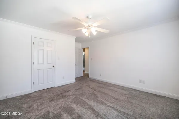 a view of an empty room with a ceiling fan