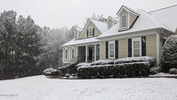a view of a house with a yard covered in snow