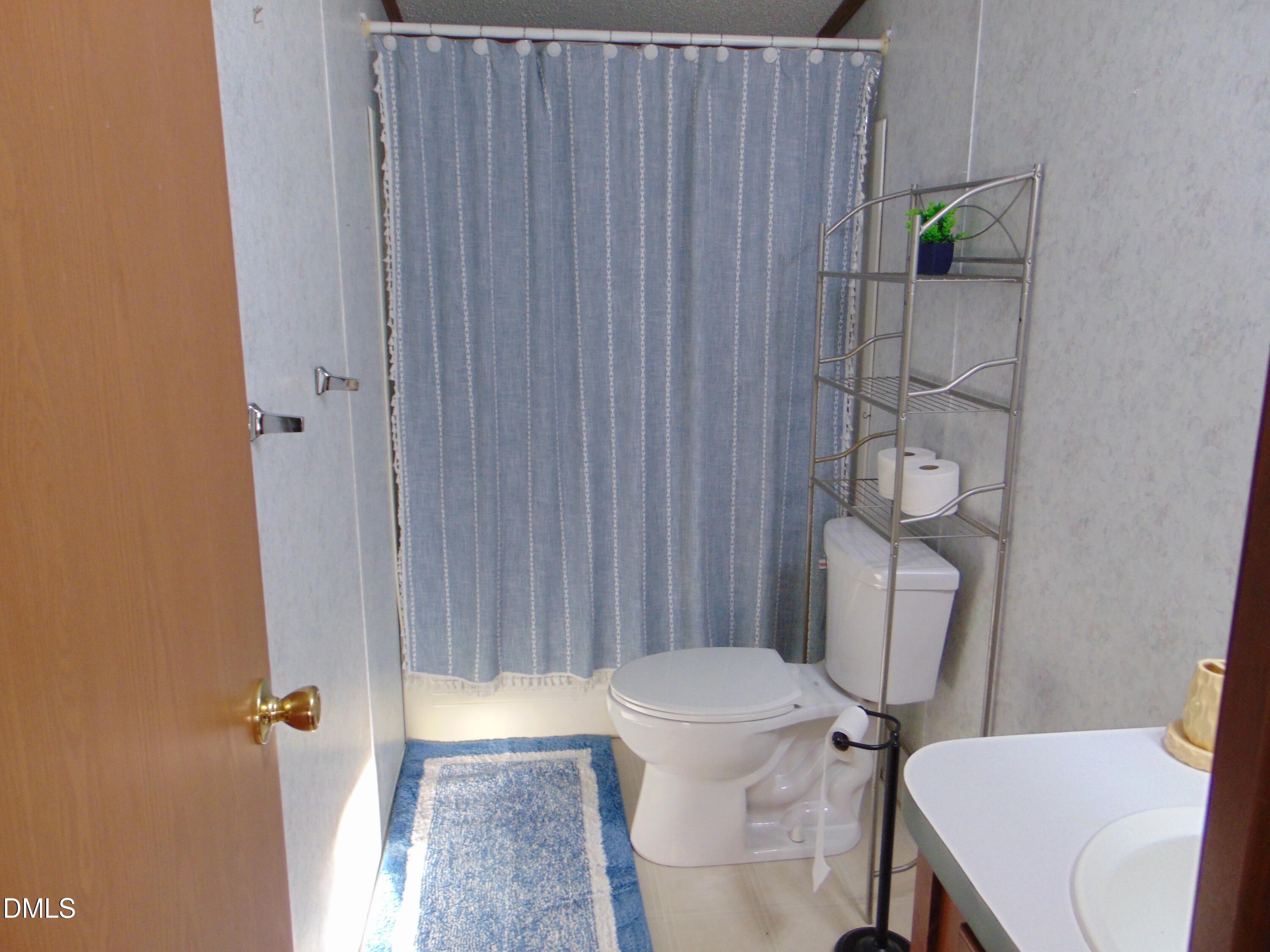 130 Lake View Road Prospect Hill, NC 27314 - Photo 68 of 73 a white toilet sitting next to a shower curtain