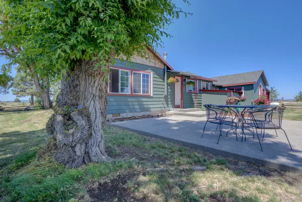 a backyard of a house with table and chairs