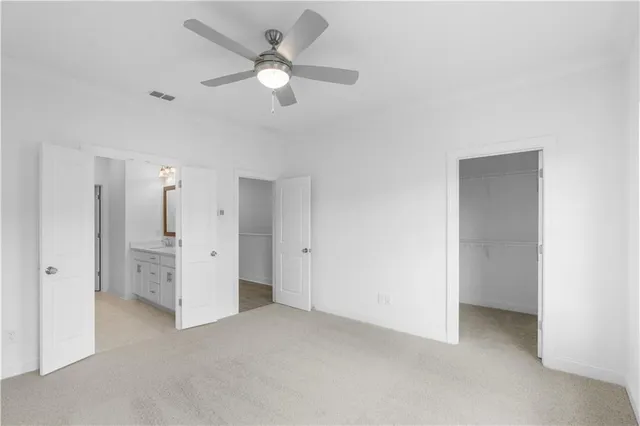 an empty room with closet and a ceiling fan