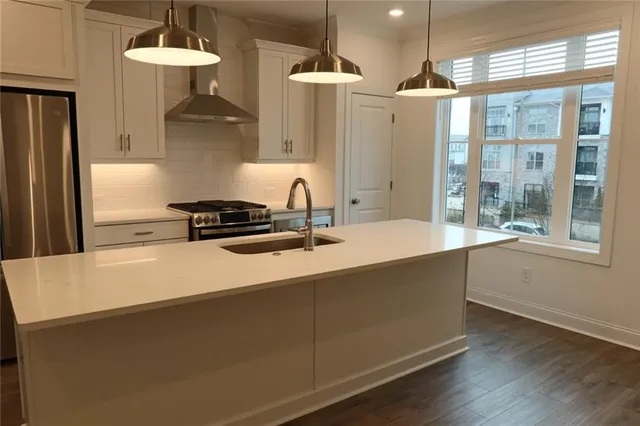 a kitchen with stainless steel appliances a stove a refrigerator and cabinets