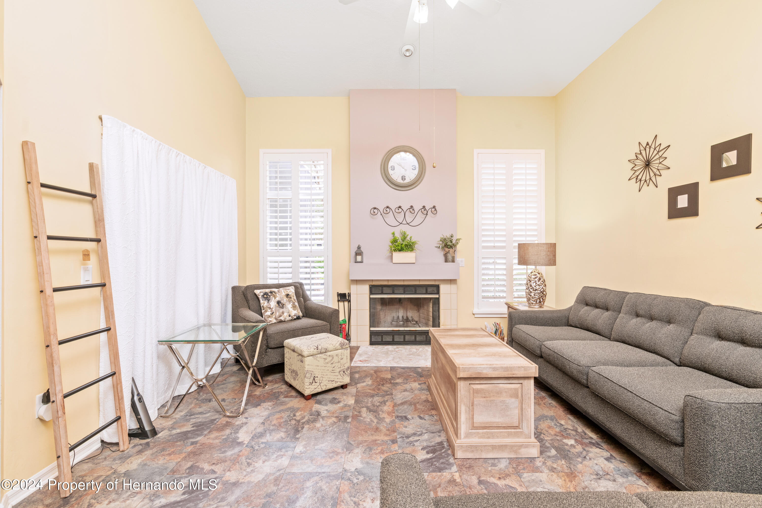 1 Byrsonima Loop Homosassa, FL 34446 - Photo 18 of 41 a living room with furniture a fireplace and a large window