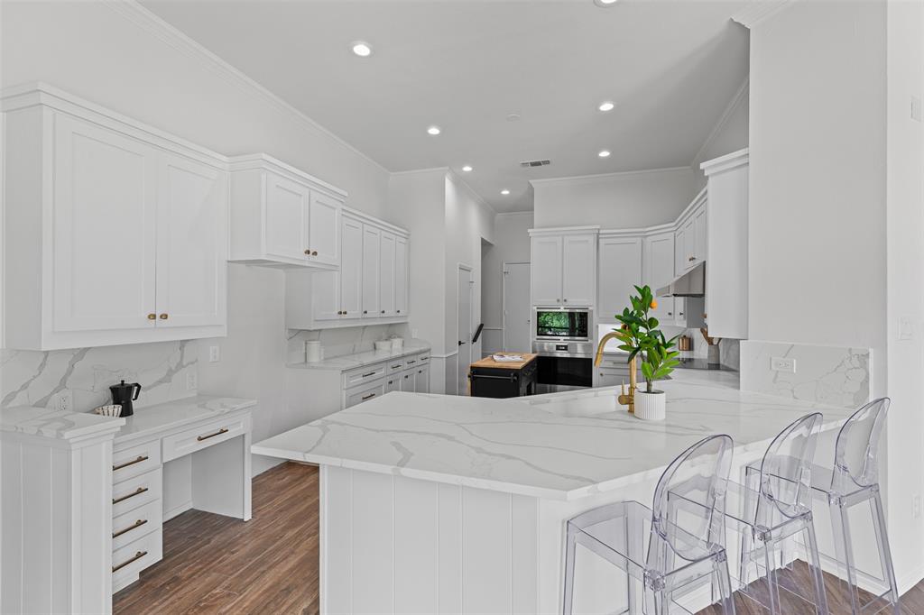 2109 Greta Lane Fort Worth, TX 76120 - Photo 13 of 40 a kitchen with stainless steel appliances kitchen island granite countertop a sink a refrigerator and white cabinets