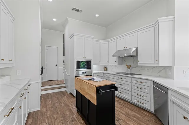a kitchen with cabinets appliances a sink and a counter space