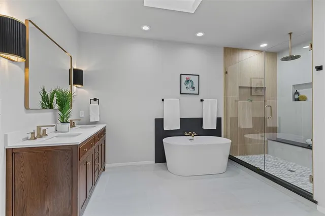 a en suite bathroom with a double vanity sink a mirror and a shower