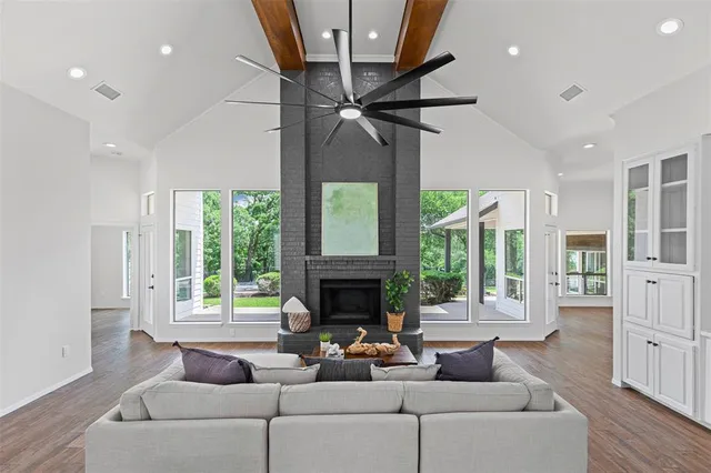 a living room with furniture a fireplace and a floor to ceiling window