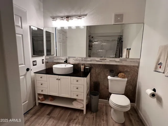 a bathroom with a toilet sink and mirror