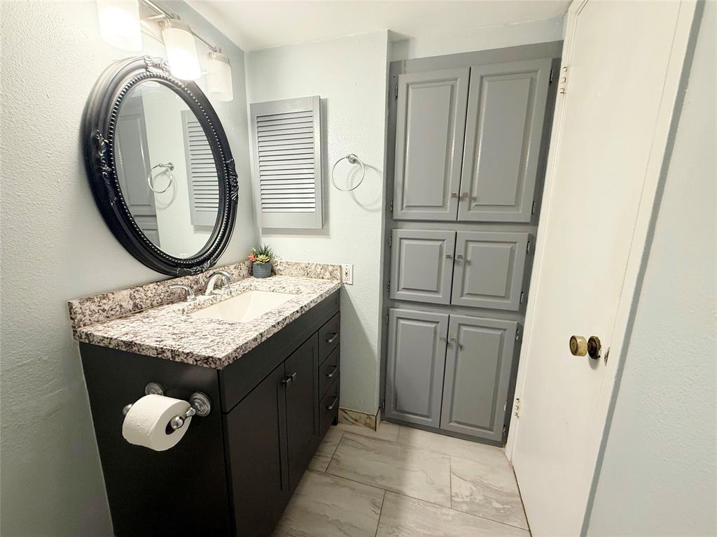 11311 Audelia Road, Unit 161 Dallas, TX 75243 - Photo 12 of 15 Bathroom featuring vanity, light marble finish flooring, and a textured wall