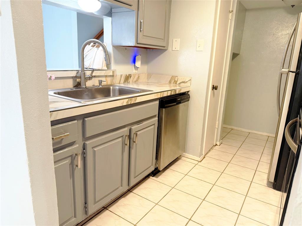 11311 Audelia Road, Unit 161 Dallas, TX 75243 - Photo 7 of 15 Kitchen featuring light tile patterned flooring, light countertops, appliances with stainless steel finishes, and gray cabinets