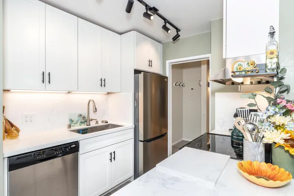 a kitchen with stainless steel appliances kitchen island granite countertop a refrigerator and microwave