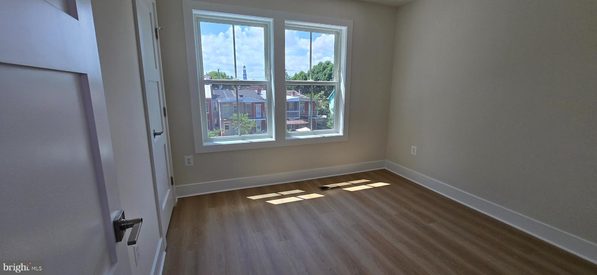 412 Chapel Alley, Unit 1 Frederick, MD 21701 - Photo 21 of 41 a view of an empty room with wooden floor and a window