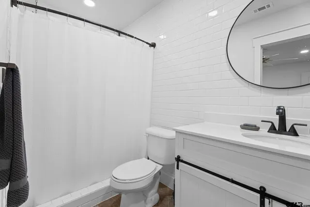 a bathroom with a sink a toilet and a mirror