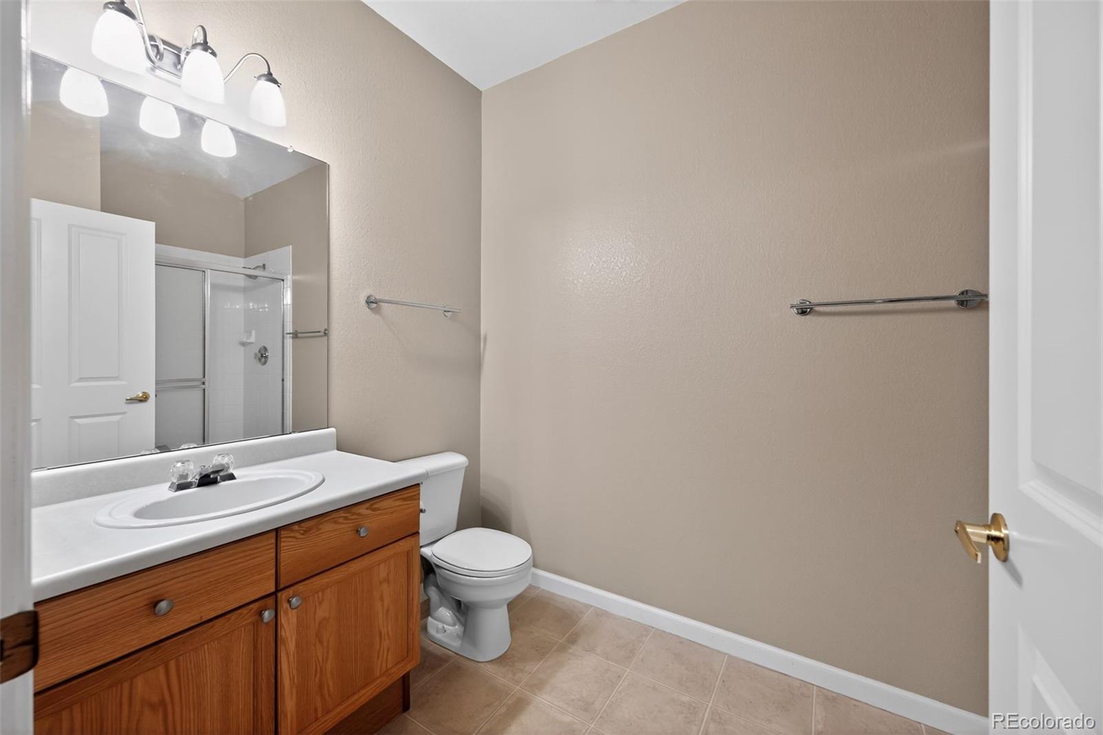 4064 South Carson Street, Unit 101 Aurora, CO 80014 - Photo 30 of 32 a bathroom with a double vanity sink mirror and toilet