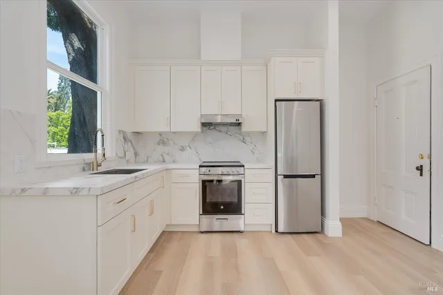 a kitchen with a white cabinets and white appliances