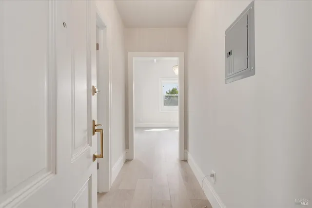 an empty room with chandelier fan and windows