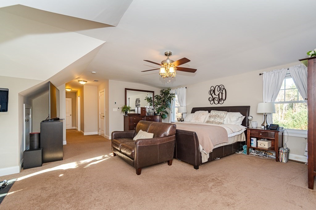 30 April's Way Tewksbury, MA 01876 - Photo 25 of 42 a spacious bedroom with a bed and a chandelier