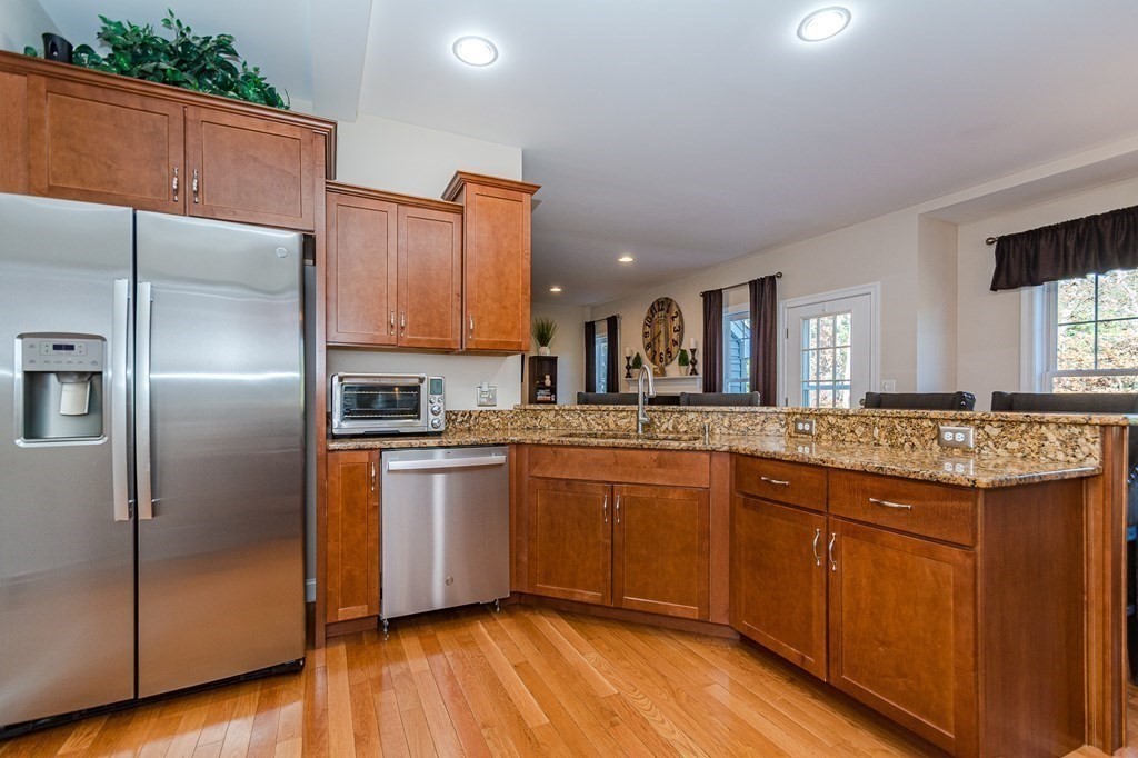 30 April's Way Tewksbury, MA 01876 - Photo 9 of 42 a kitchen with stainless steel appliances granite countertop a refrigerator a sink and wooden cabinets
