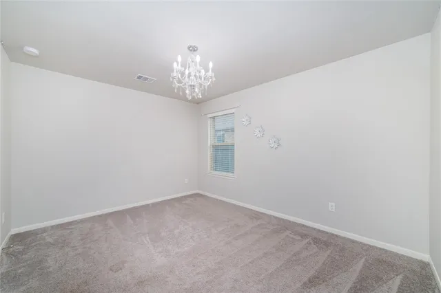 en empty room with a chandelier fan