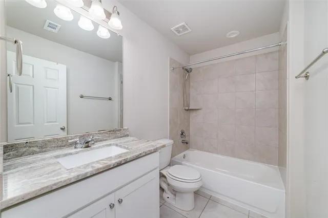 a bathroom with a granite countertop sink a toilet and shower
