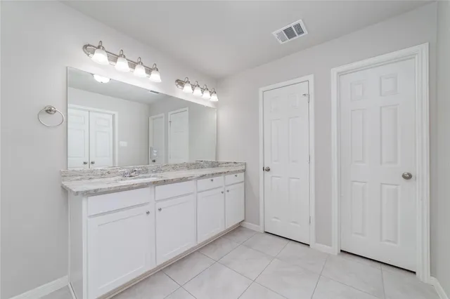 a bathroom with a granite countertop sink a mirror and a vanity