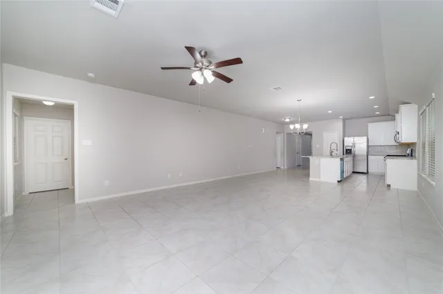 a view of a big room with a ceiling fan and window