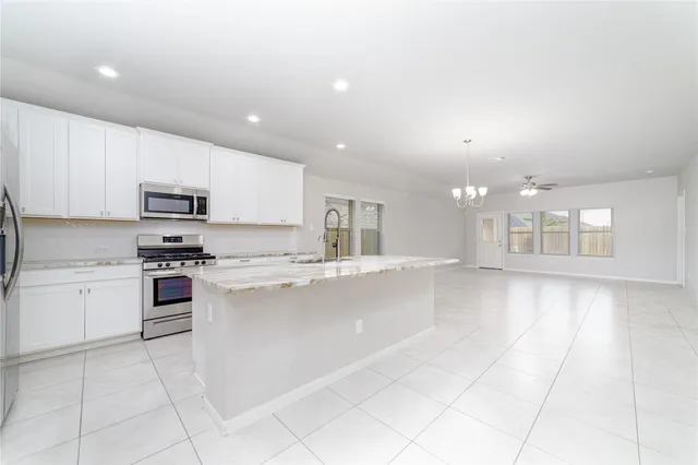 a large kitchen with stainless steel appliances granite countertop a large counter top and a stove top oven