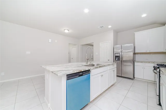 a kitchen with a sink refrigerator and cabinets