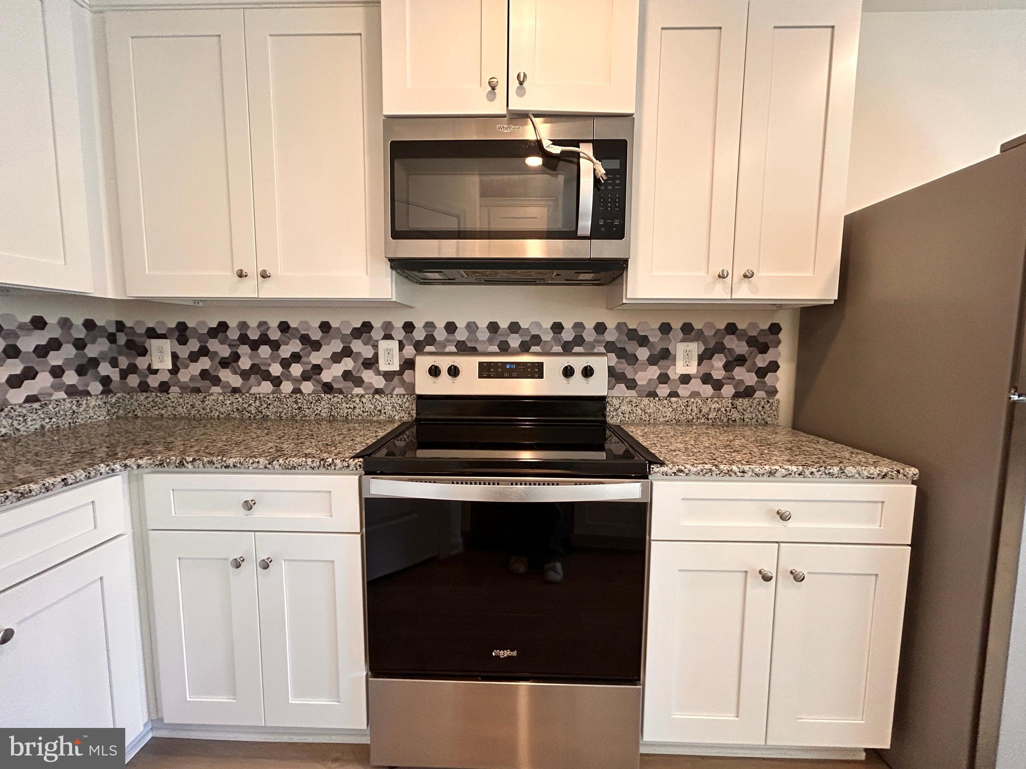 90 Rappahannock Run Falling Waters, WV 25419 - Photo 5 of 48 a kitchen with granite countertop white cabinets and white appliances