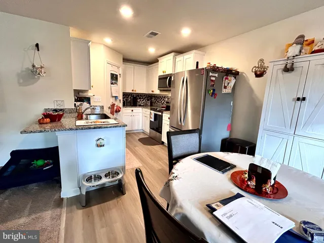 a kitchen with stainless steel appliances a sink a stove a refrigerator and cabinets