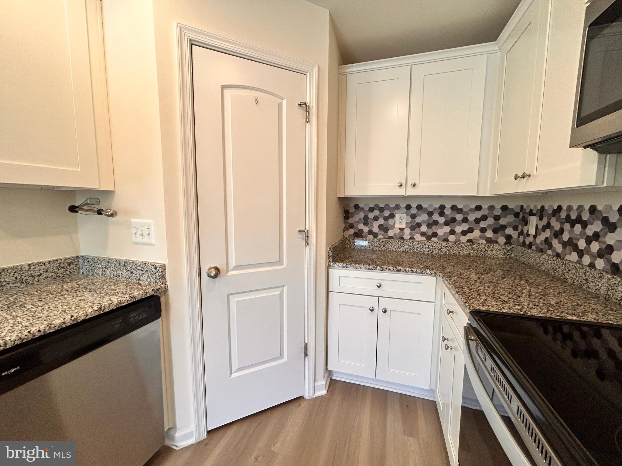 90 Rappahannock Run Falling Waters, WV 25419 - Photo 6 of 48 a kitchen with granite countertop white cabinets and black appliances