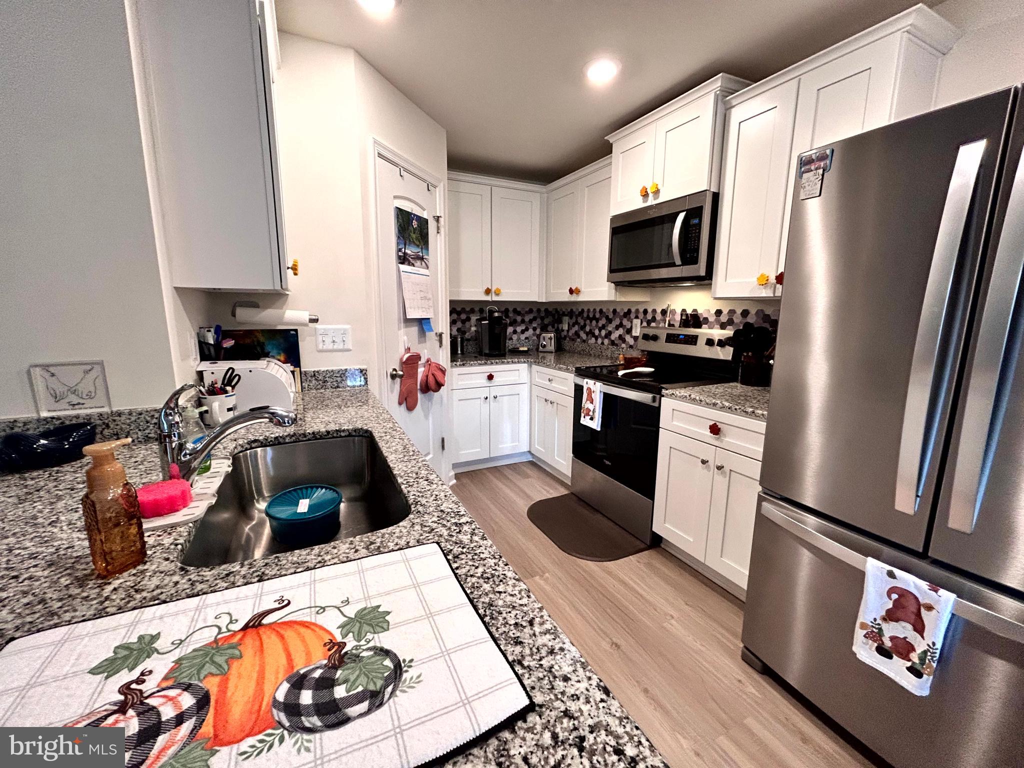 90 Rappahannock Run Falling Waters, WV 25419 - Photo 8 of 47 a kitchen with stainless steel appliances a stove a sink and a refrigerator