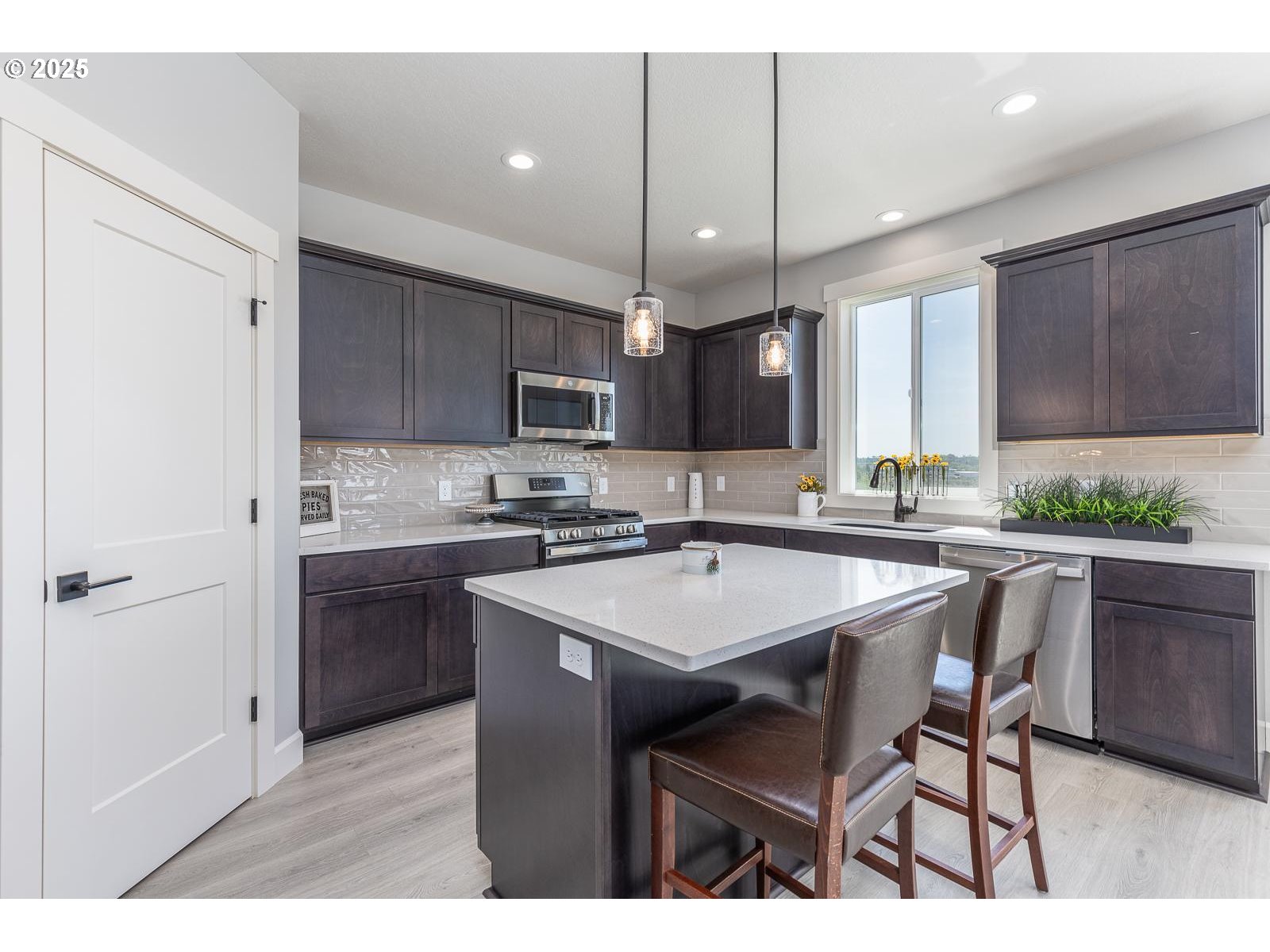 856 East Autumn Avenue Hermiston, OR 97838 - Photo 5 of 25 a kitchen with a dining table chairs sink and cabinets