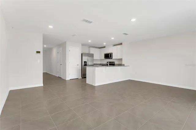 a view of kitchen with kitchen island and stainless steel appliances