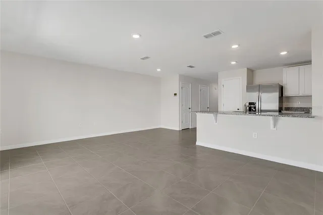 a kitchen with stainless steel appliances granite countertop a refrigerator a stove a sink a microwave a oven and a refrigerator