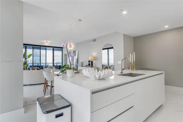 a kitchen with sink refrigerator and large window