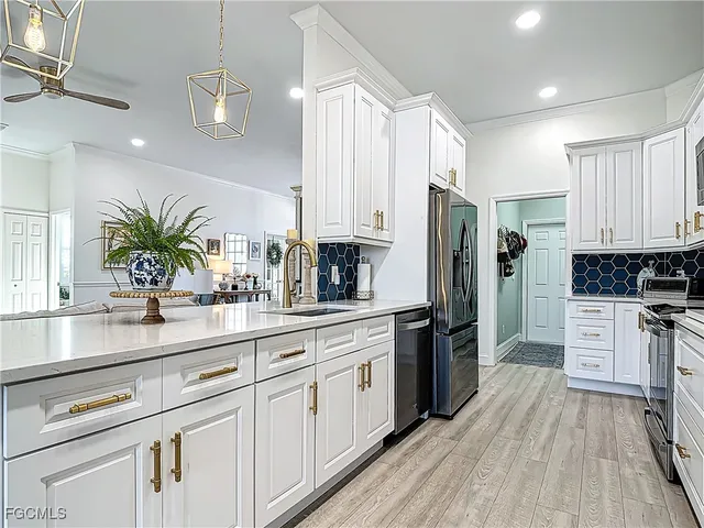 a kitchen with white cabinets and stainless steel appliances