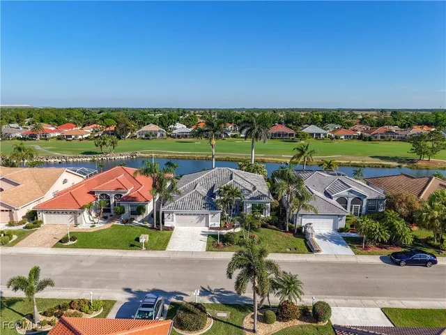 an aerial view of a city with lots of residential buildings and ocean view in back