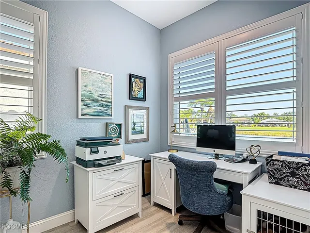 a view of a workspace with furniture and a window
