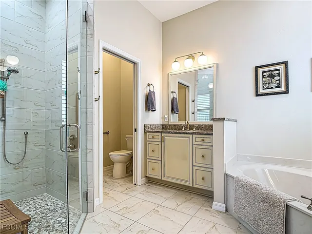 a bathroom with a granite countertop sink toilet and shower