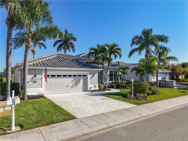 a front view of a house with a yard and palm trees